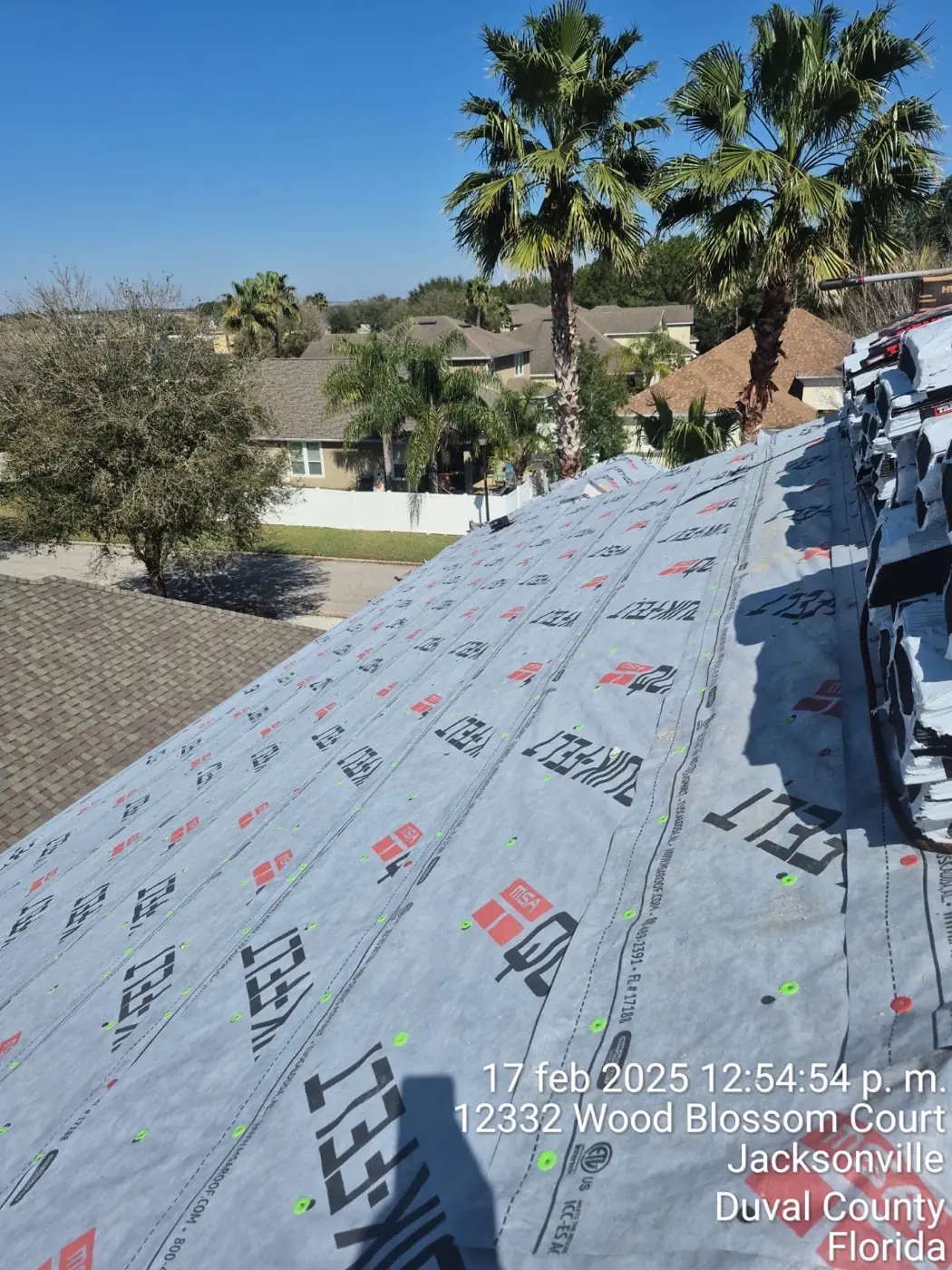 Aerial view of a tear-off on a large lakefront home with a pool enclosure
